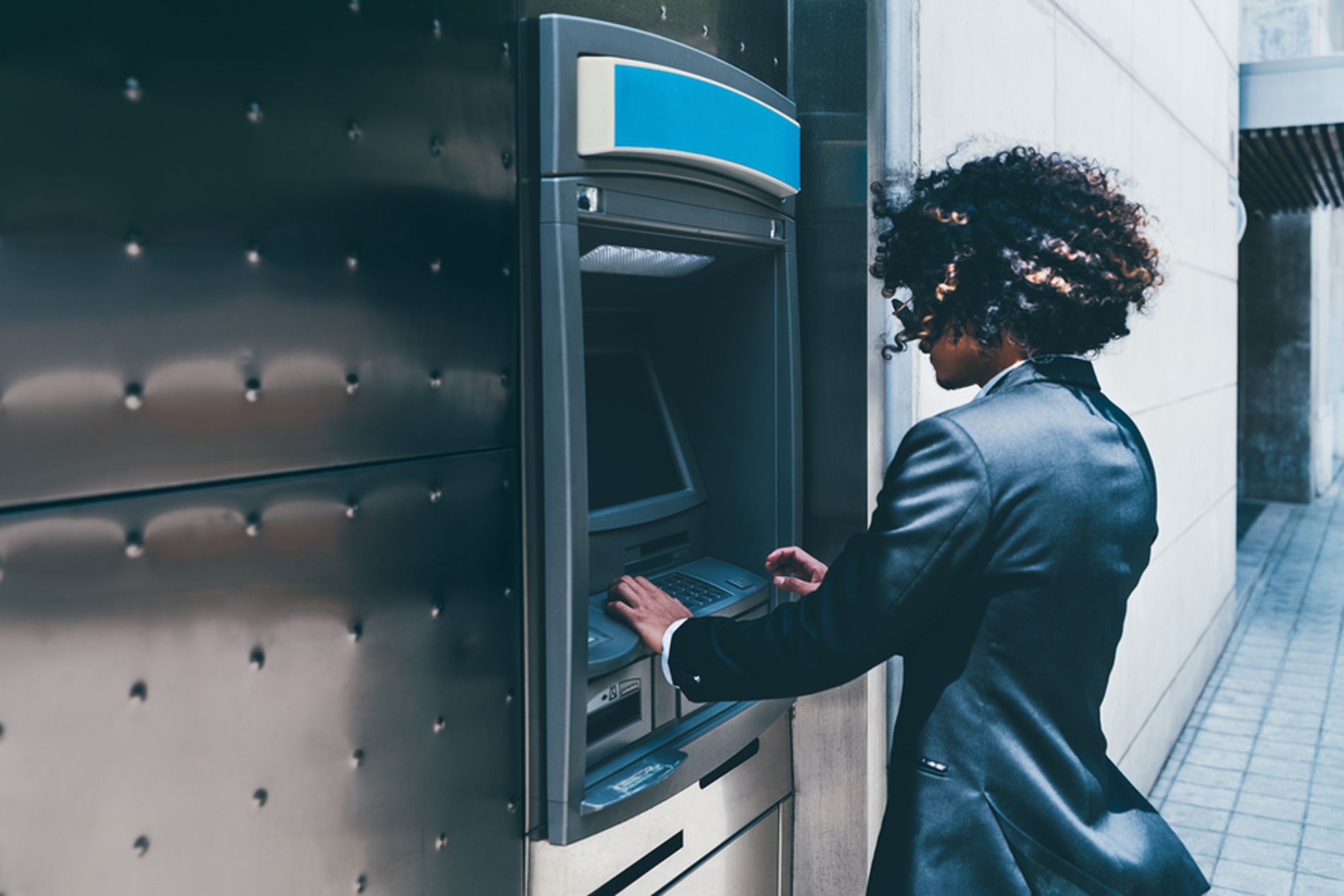 Woman operating an ATM.